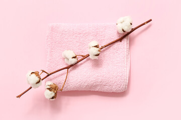 Clean towel and beautiful cotton branch on pink background