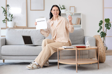 Young woman with refund form and money sitting on sofa at home