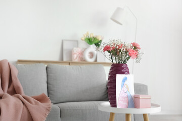 Naklejka premium Vase with flowers, card for Mother's Day and gift on table in living room