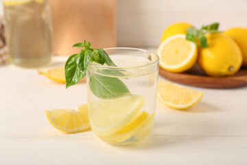 Glass of tasty lemonade on white wooden table, closeup