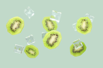 Ice cubes with slices of fresh kiwi on grey background