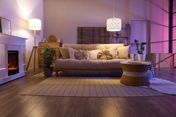 Cozy interior of dark living room with fireplace, sofa and table