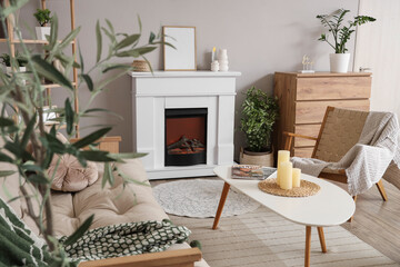Fireplace, armchair and table in interior of light living room