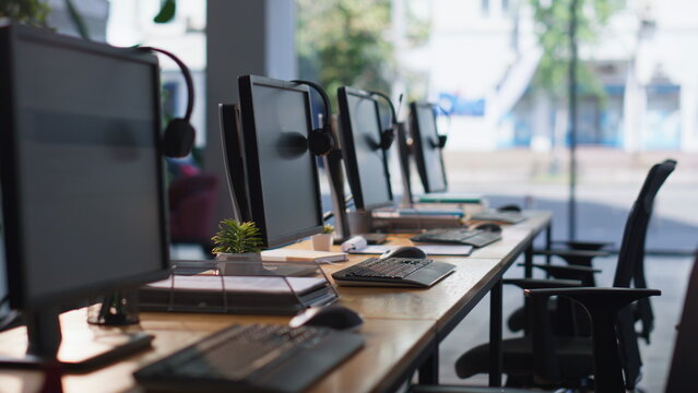 Empty office desks computers and headphones at workspace. Organized call center - Powered by Adobe