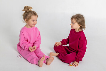 Two funny cute girls playing and having fun. Children with smiles and funny emotions on a light background