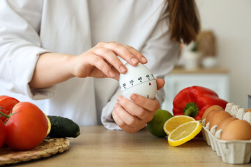 Woman with modern kitchen timer at table in room, closeup