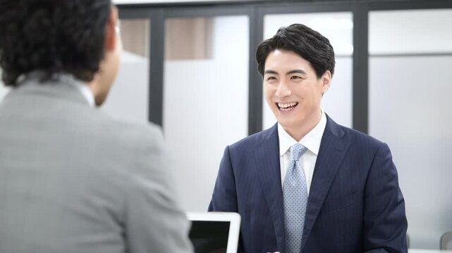 明るい白い綺麗な会議室で、打ち合わせや営業の提案、面談や就活などをするビジネスシーンの男性の正面の動画