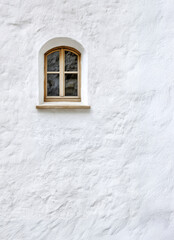 Small Arch Window in White Textured Wall.