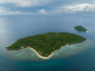 Topical Island with sandy beach under blue sky and clouds. Buh-Buh Island in Zamboanga, Philippines.