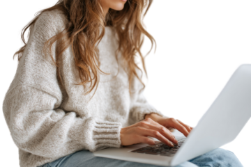 A woman is sitting on a chair and typing on a laptop