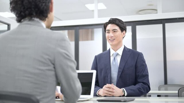 明るい白い綺麗な会議室で、面談や就活、打ち合わせや営業の提案、ビジネスシーンの男性の正面の動画