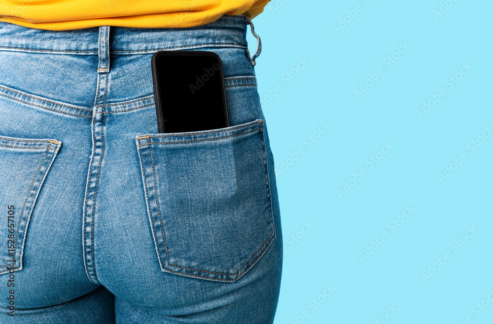 Poster cropped view of female having cellphone with blank screen in jeans pocket on blue studio background,