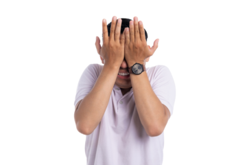 Embarrassed young man covering face with both hands showing shy and awkward expression isolated on transparent background