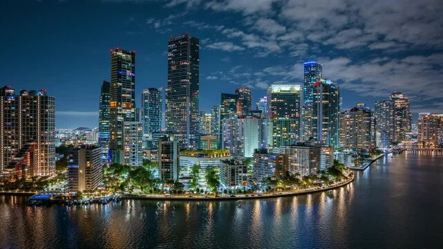 Experience the breathtaking and vibrant nightlife of Downtown Miami and Brickell Key through this stunning aerial hyperlapse. Witness the city lights beautifully reflecting on the water surface