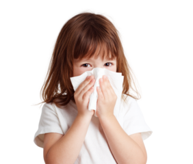 A young girl is holding a tissue to her face, possibly because she has a cold