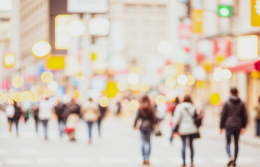 Blurred street scene with pedestrians walking buildings and lights visible.Premium urban photos for poster, banner and pamphlet backgrounds