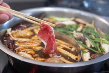 shabu-shabu or sukiyaki. Beef slice on top of hot pot, Fresh beef slices with ingredients background for Japanese shabu-shabu or Sukiyaki.
