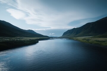 Fototapeta premium Serene Landscape with Calm River Flowing Through Majestic Mountains Under a Soft Blue Sky and Whispering Clouds