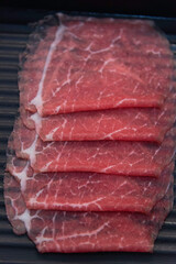 shabu-shabu or sukiyaki. Beef slice on top of hot pot, Fresh beef slices with ingredients background for Japanese shabu-shabu or Sukiyaki.