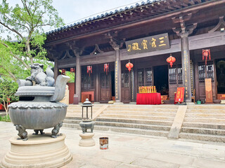 Traditional Chinese temple with red lanterns, stone incense burner, and calligraphy plaque,...