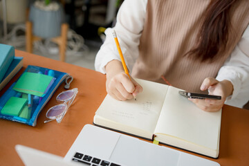Asian girl student doing exam hand holding pencil writing answer in university classroom education high school or university student taking notes while preparing for exam
