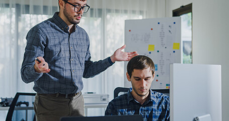 Team adult male engineer collaborate on robotic hand project using AI code solutions machine learning at tech workspace. Artificial intelligence interface, collaboration support prototype development.