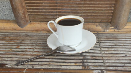a glass of warm coffee served on a bamboo table