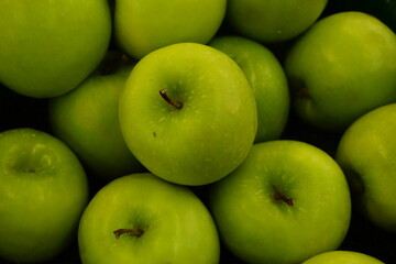 A pile of fresh green apples on top of the basket