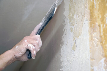 A man plastering a wall with a spatula