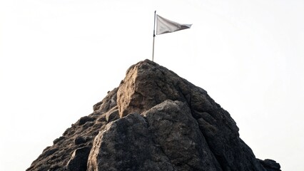Fototapeta premium Close up flag standing on rock peak symbol of achievement success ambition goal with white background