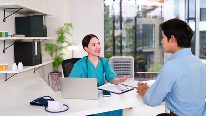 Asian Women Doctor Consults with Male Patient in Clinic Office Medical Exam Healthcare Professional Explaining Diagnosis Treatment Options