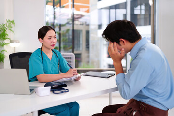 Fototapeta premium Asian Female Doctor Consulting Sad Adult Man Patient in Clinic Office for Healthcare Checkup and Treatment Plan Mental Health Support