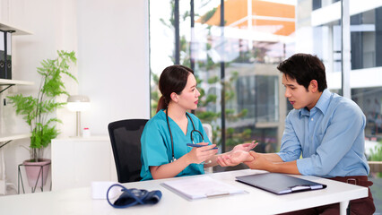 Asian Doctor Examining Young Asian Male Patient Wrist Pain Consultation and Medical Care Health Checkup in Clinic Professional Diagnosis and Treatment