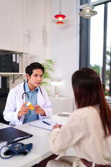Doctor's Consultation: In a modern medical setting, a caring doctor in a white coat consults with a...
