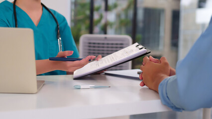 Asian Female Doctor Consulting Patient Healthcare and Medical Checkup in Clinic Office Examining Diagnosis and Treatment Plan with Thermometer on Table