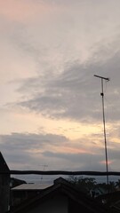 scenery of the gray sky with the roofs of houses and antenna