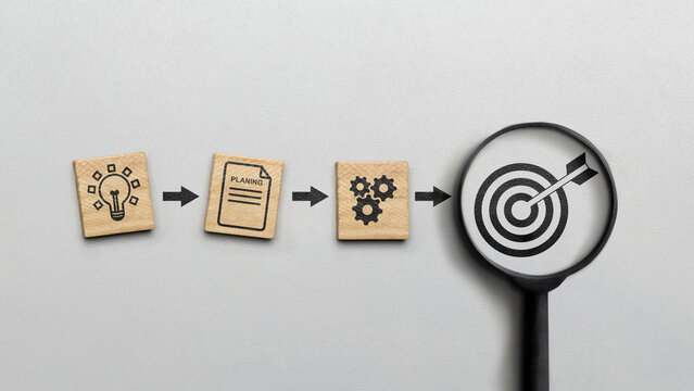 Magnifying glass showing a dart and an arrow icon on a white background. Concept of the action plan