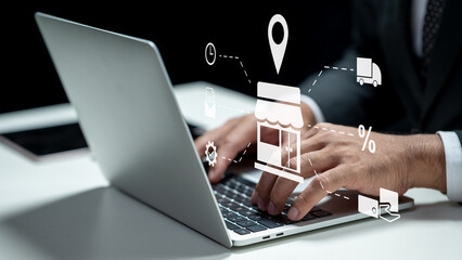 Businessman using a laptop while showing an icon of a shop for ecommerce. Tablet on the table. Technology innovation on a virtual screen. Concept of ecommerce or small business