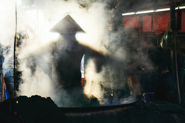 Vietnamese woman worker works in reed dyeing workshop at wicker mat factory in village in Vietnam