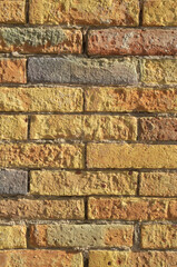 Old colorful crumbling brick wall closeup