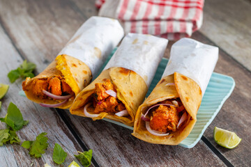 Egg chicken roll is a popular street food made with a flaky paratha, spiced chicken, egg layer, onions, and sauces, wrapped and served hot.
