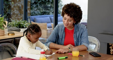 Mother offering pencil at table, guiding workbook counting, hugging daughter writing number - Powered by Adobe
