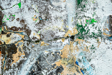 Abstraction of crumbling graffiti on a city street wall. Colorful abstract background. Old, cracked, peeling paint on the wall as a background.