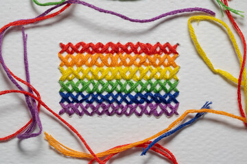 Bandera del orgullo LGBTQ+ bordada en punto de cruz con hilos de colores al rededor