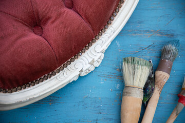 Painting a wooden furniture outdoors, an eco-friendly re-use business.