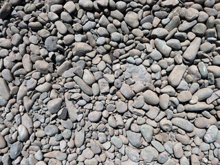 Grey darker pebbles stone for background., backdrop