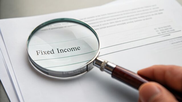 Fixed income concept. Magnifying glass focuses on "Fixed Income" document, highlighting financial analysis.