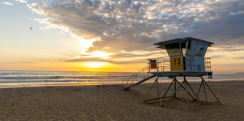 Sun setting over the Pacific Ocean from public lifeguard tower 13 at Mission Beach in San Diego,...