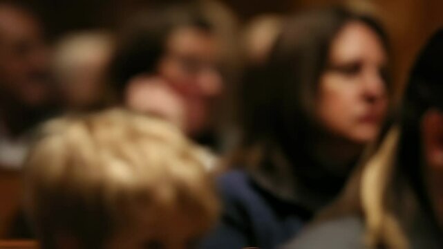 A young child sitting in the front row, their eyes wide with wonder and awe as they watch the choir with fascination and joy.