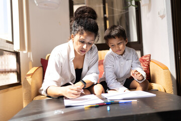 Mother helping son with homework, homeschooling during quarantine